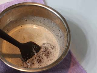 3、巧克力熔岩杯子蛋糕,	用刮刀同一方向画圈搅拌至顺滑后放凉备用（刚开始搅拌时会是比较渣的状态，正常现象。）