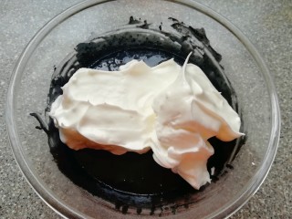 11、蜂窝煤戚风蛋糕,将打发好的蛋白分成三份，取中间的三分之一加入到蛋黄糊里面，用硅胶刮刀采用切拌和翻拌的方法混合均匀。