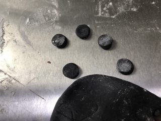 11、猪猪馒头,取0.5克黑色面团揉圆压扁，取0.3克黑色面团揉圆放在压扁的黑色面皮上当作礼帽