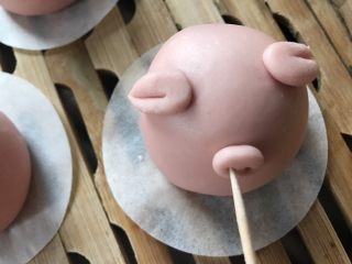 10、猪猪馒头,将猪鼻子沾少许水放在合适位置，轻轻压扁，用牙签戳两个洞