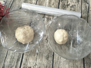 4、紫薯肉松陷蛋黄酥,两个面团全部捏成团，盖上保鲜膜醒20分钟。