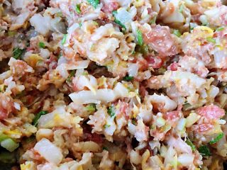 8、玉米面酸菜蒸包,酸菜放入入味的肉馅中再放入油、香油、盐、味精搅拌均匀入味蒸包馅制作完成