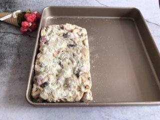 11、网红草莓雪花酥,整理好后趁着有余温均匀的撒上一点奶粉，然后翻面在另一面也均匀撒上一层奶粉