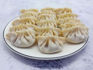11、酸辣可口的【酸汤饺子】,拿一个饺子皮、加肉末在饺子皮中间、依次包成褶子。