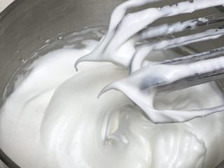 4、芒果蛋糕卷,加入第三次的细砂糖15克,继续搅打50圈,在搅打时明显感觉打蛋器有阻力,这时的蛋白细腻光滑,而且亮晶晶,打蛋头上出现直立的小尖峰。