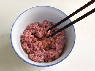 4、四喜蒸饺,往搅好的肉馅中加入姜末、生抽、料酒和盐，用筷子顺着一个方向搅拌上劲。