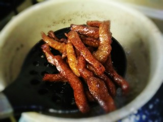 5、#猪年#麻辣孜然猪肉干,炸到图中状态的颜色就可以捞出。