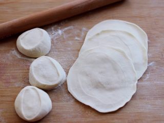 8、百吃不厌的韭菜盒子,把醒发好的面团排气揉匀后，用手搓成长条后，用刀切成大小一致的剂子，摁扁再用擀面杖擀成圆形薄面皮。