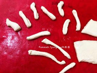 8、自制油条,打开保鲜膜，手上抹少许油，把面团轻轻按开一下，按的时候别太用力，这样炸的时候油条才有张力，炸出来的油条才有孔洞，从中间切开，分成对面团，再切用条状，拿起一条面团，捏住两头稍微拉长，对折，再捏住两头，扭转一下，放入油中，放入油中用筷子快速翻动油条，让它能更好的受热均匀，这样炸出来的油条更有孔洞，上色也会更均匀