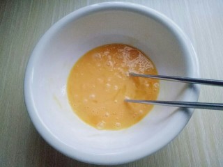 3、快手早餐~芝香馒头丁,用筷子将鸡蛋打散。