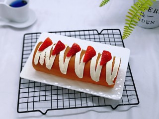 19、红丝绒草莓奶油蛋糕卷～下午茶必备甜品,留下的奶油装入裱花袋，挤在蛋糕卷上，又装饰了草莓，这样就完成啦。