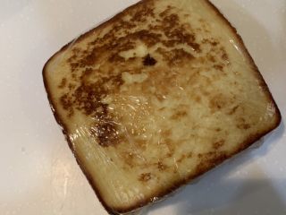 23、厚蛋烧芝士午餐肉三明治,盖上面包，把保鲜膜包紧，然后对半切开就可以吃了