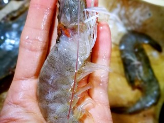 8、家庭简易版螃蟹海鲜粥,开始处理虾，虾皮保留，从虾头处把虾背上的黑线抽出。我一只手没拍照出来。