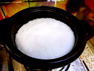 11、家庭简易版螃蟹海鲜粥,把电饭煲已经煮好的白粥倒入傻锅中。