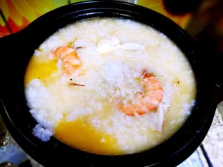 15、家庭简易版螃蟹海鲜粥,连油带海鲜一同倒入砂锅中，大火开始煮粥，这时放适量盐，白胡椒粉，数滴香油。