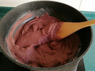 5、自制红豆沙馅,将过筛后的红豆泥放入不粘锅里，开到中火。最好要用不粘锅哦。