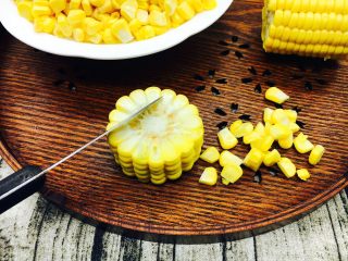 3、奶香鲜玉米汁(豆浆机版),把玉米洗干净,先切成段,然后用刀子把玉米粒切下来。