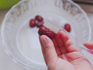 4、苹果小米粥,红枣用一次性牙刷或者小刷子刷洗干净红枣表层的尘土，冲洗干净