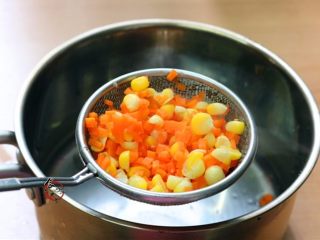 5、晶莹剔透又鲜又爽的水晶虾饺,将胡萝卜、玉米粒焯熟，捞起沥干水，玉米粒稍微剁碎