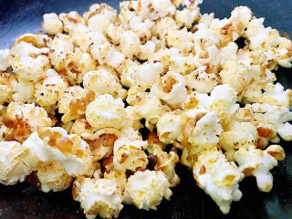 2、原味爆米花,听不见砰砰砰的声音,说明已经好了,快速的倒入糖,翻动或者晃动锅让爆米花均匀地沾上糖。