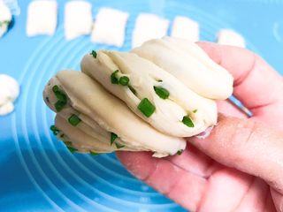 21、蓬松柔软的香葱花卷,用手捏住上下两头，往后面扭合在一起，一个花卷就做好了