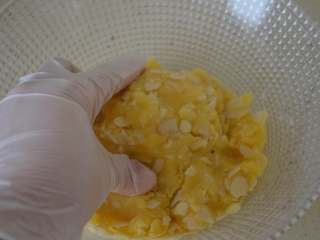 12、杏仁酥,带烘焙手套,用手慢慢揉匀,无需过度揉搓,杏仁片揉均匀就可以。揉好的面团不能太干,应该是比较湿润的状态,烤出来才会比较酥,如果揉好的面团较干,可以适量再添加少许油。