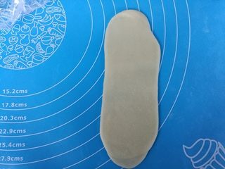 10、福满楼红豆酥,全部做完后，取过第一个卷，按扁，擀成长条。