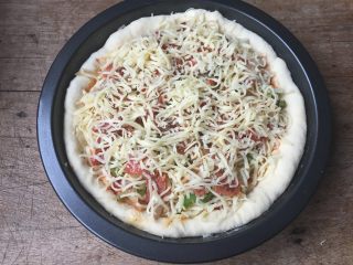 11、双酱培根披萨,按照一层菜一层芝士的顺序放入培根、洋葱丝、青椒丝,最上面再撒适量芝士;