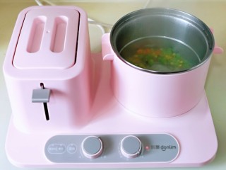 3、洋葱圈鸡蛋肉糜饼,现在将胡萝卜丁，玉米粒，豌豆焯水，早餐机锅中加入水，烧开，下入彩蔬，高档煮2分钟捞出淋干水分。