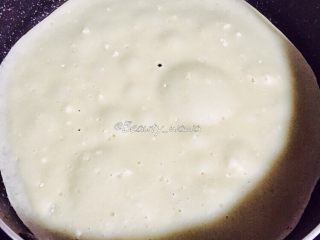 7、快手版老北京春饼（土豆丝卷饼）,勺子舀适量面糊倒入锅中，晃动均匀，形成薄薄的饼皮，小火加热