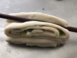 8、葱油花卷,用筷子横向在中间压一下，端起来从中间轻轻往两边拉开一点。
