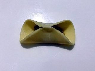 5、四喜饺子，让生活喜气洋洋,将面皮的两边对折，中间捏在一起。