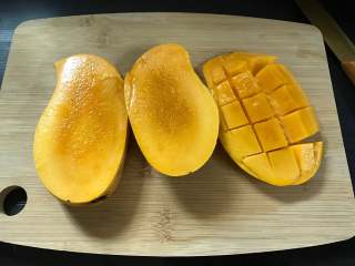 2、芒果椰汁黑米粥 ,芒果取核切成小丁。