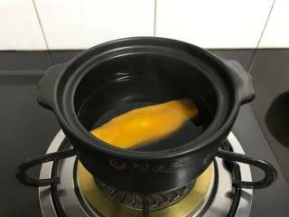 4、芒果椰汁黑米粥 ,先把芒果核放入煮3分钟上。