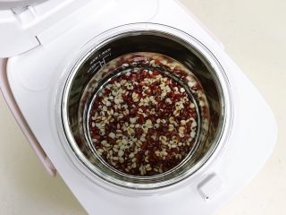 3、红豆薏米甜酒酿,玻璃内胆放入电饭煲，倒入纯净水。