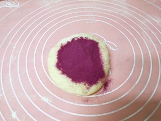 6、紫薯花卷,把熟紫薯粉倒在小面团上。