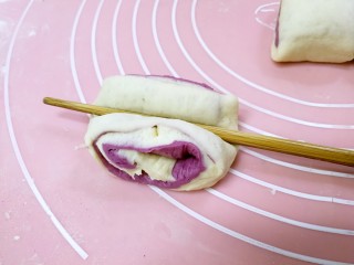 14、紫薯花卷,取一个剂子，用筷子横在中间向下压一下。