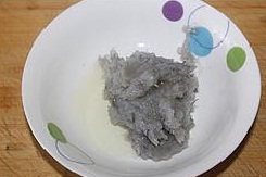 3、小米虾滑粥,再放入少许料酒和蛋清顺着一个方向搅打均匀；