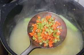 9、小米虾滑粥,将切成小碎丁的胡萝卜和芹菜丁放入小米粥中搅匀；