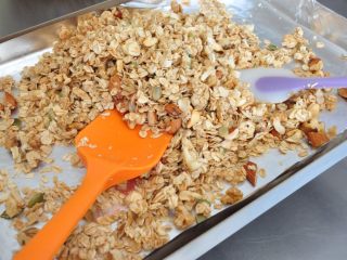 16、格兰诺拉麦片,用刮刀翻拌一下，让麦片受热均匀，铺平继续烘烤。（重复步骤13-16动作3次，一共烘烤30分钟。）