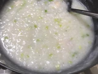 8、美味虾粥,看到粥基本煮开浓稠的时候转中火放入虾和一半的葱花