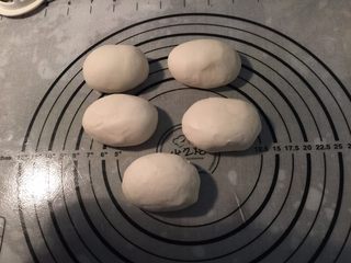 7、贝壳黑芝麻花卷,把面团压扁再次揉光滑，分成5等份，把小面团也揉至光滑成椭圆形，松弛10分钟