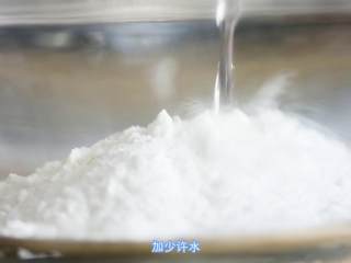 3、玫瑰松糕,米粉内加入水。搅拌均匀，水一次不要加多，慢慢加，水量要根据自己的米粉吸水性调节。