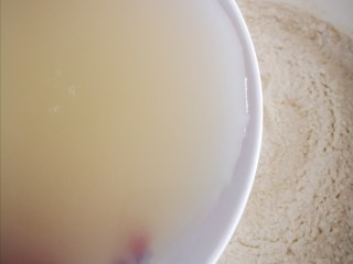 6、健康美味之蒸荞糕,将化开的酵母水倒入苦荞和面粉碗中