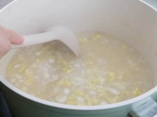 8、银鳕鱼山药粥,娃娃菜倒入小米粥搅拌均匀，熬煮10min。