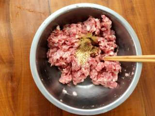 8、梅花蒸饺,倒入鸡精和十三香，继续搅拌至十三香和鸡精同肉馅完全融合。
