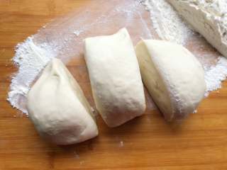 15、梅花蒸饺,面板上撒上干面粉，防止面团粘连，醒好的面团一分为三。