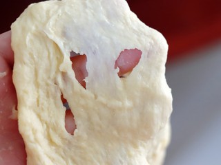 3、超绵软吐司（一次发酵）,面团揉至光滑，可以拉出粗膜的时候放入软化好的黄油，继续高速揉至黄油充分与面团混合。