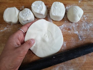 13、梅干菜肉烧饼,将面剂子按扁，擀成边上薄，中间略厚的面皮。