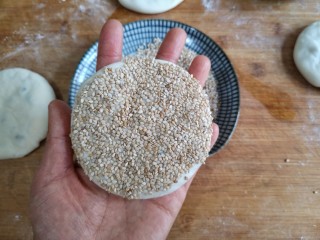 17、梅干菜肉烧饼,将刷水的一面按在芝麻盘中，沾一下。